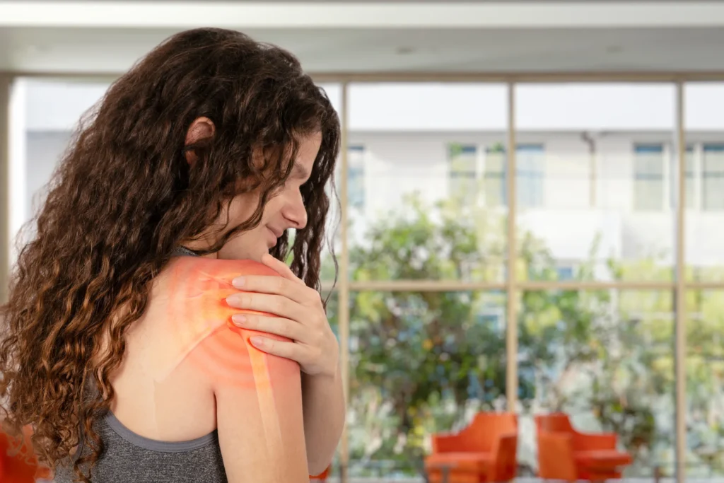 Woman holding her shoulder and a red diagram on the shoulder